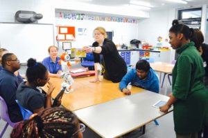 a picture of students interacting with a robot