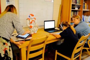 a picture of two teachers and a student with the robot