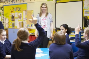 Image of a Learning and Skills Assessor Apprentice engaging a class of primary school students