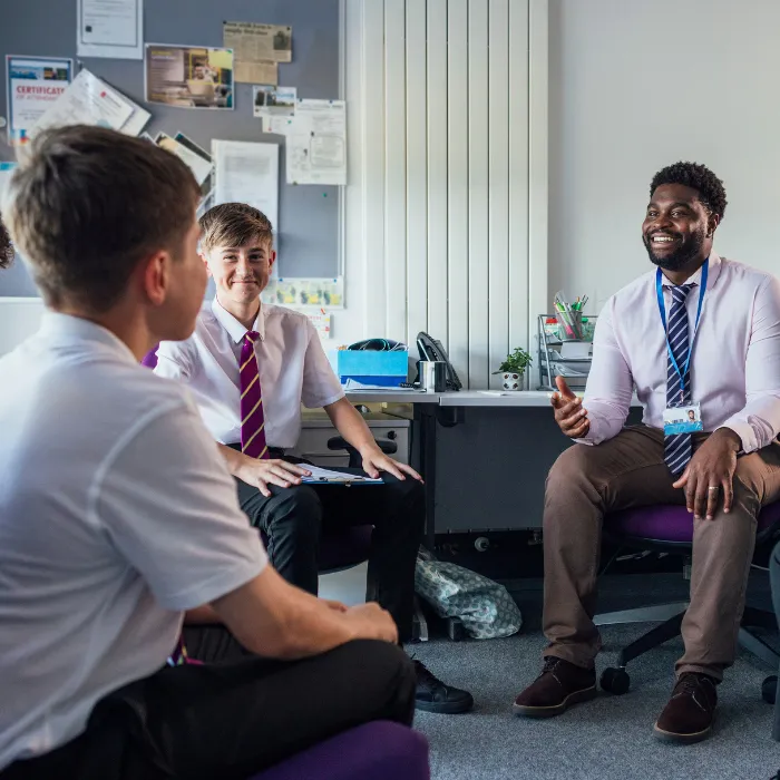 A male teacher discussing wellbeing and mental health with secondary school pupils