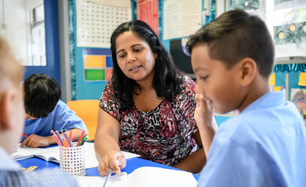 A teaching assistant helping a young boy with SEND